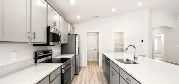 a kitchen with stainless steel appliances a sink stove and cabinets