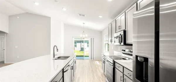 a kitchen with stainless steel appliances granite countertop a refrigerator and a sink
