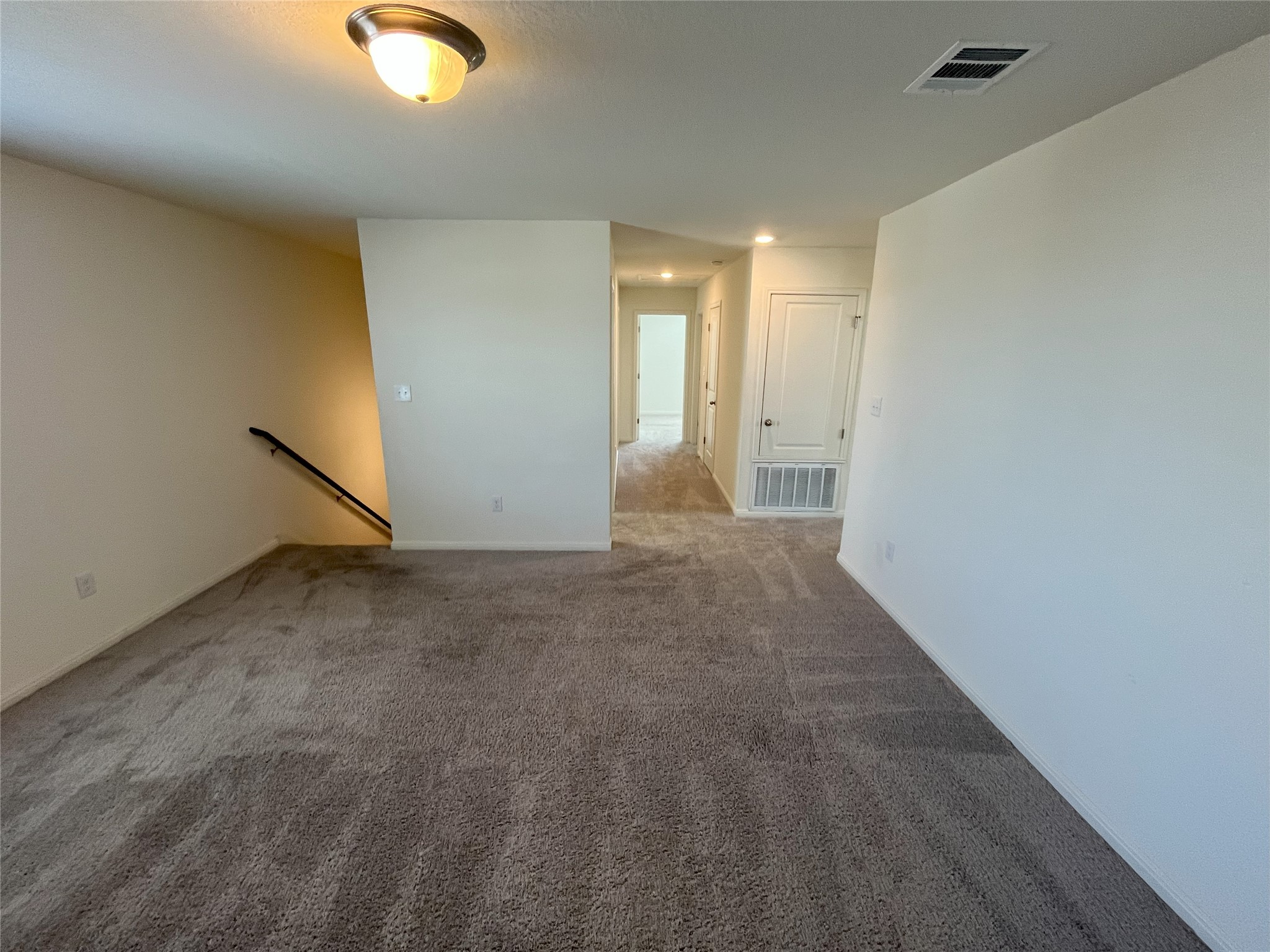 215 Light Timber Road Maxwell, TX 78656 - Photo 10 of 33 A spacious upper-level landing features neutral carpeting and a hallway leading to private rooms.