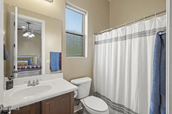 a bathroom with a sink a toilet and shower curtain