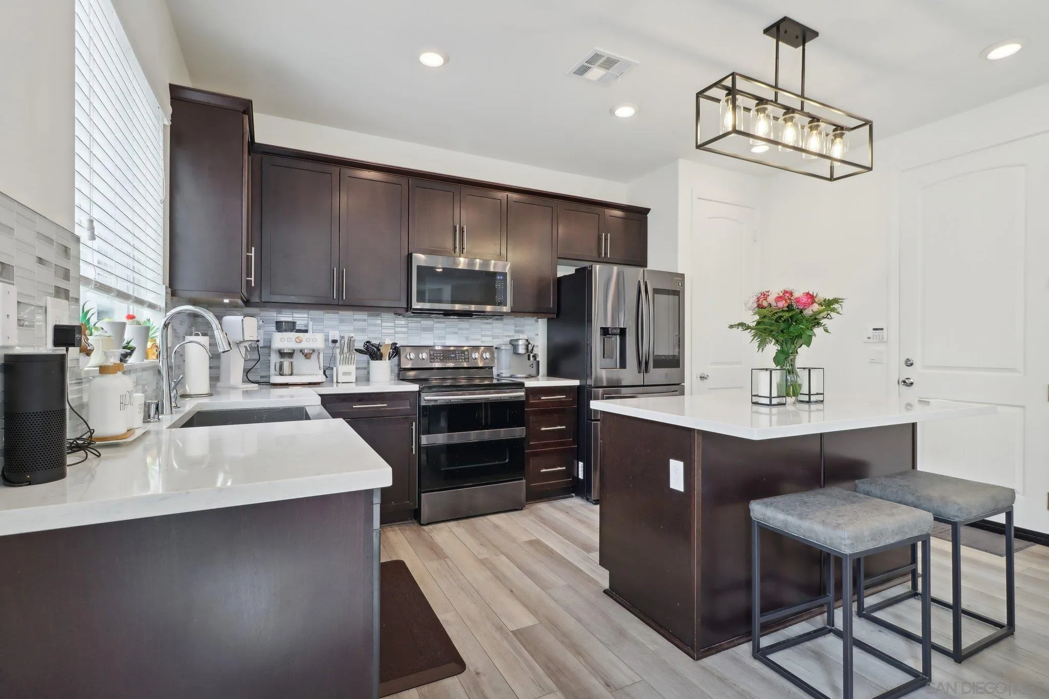 10645 Rhodes Lane Spring Valley, CA 91978 - Photo 11 of 38 a kitchen with kitchen island granite countertop a sink cabinets and stainless steel appliances