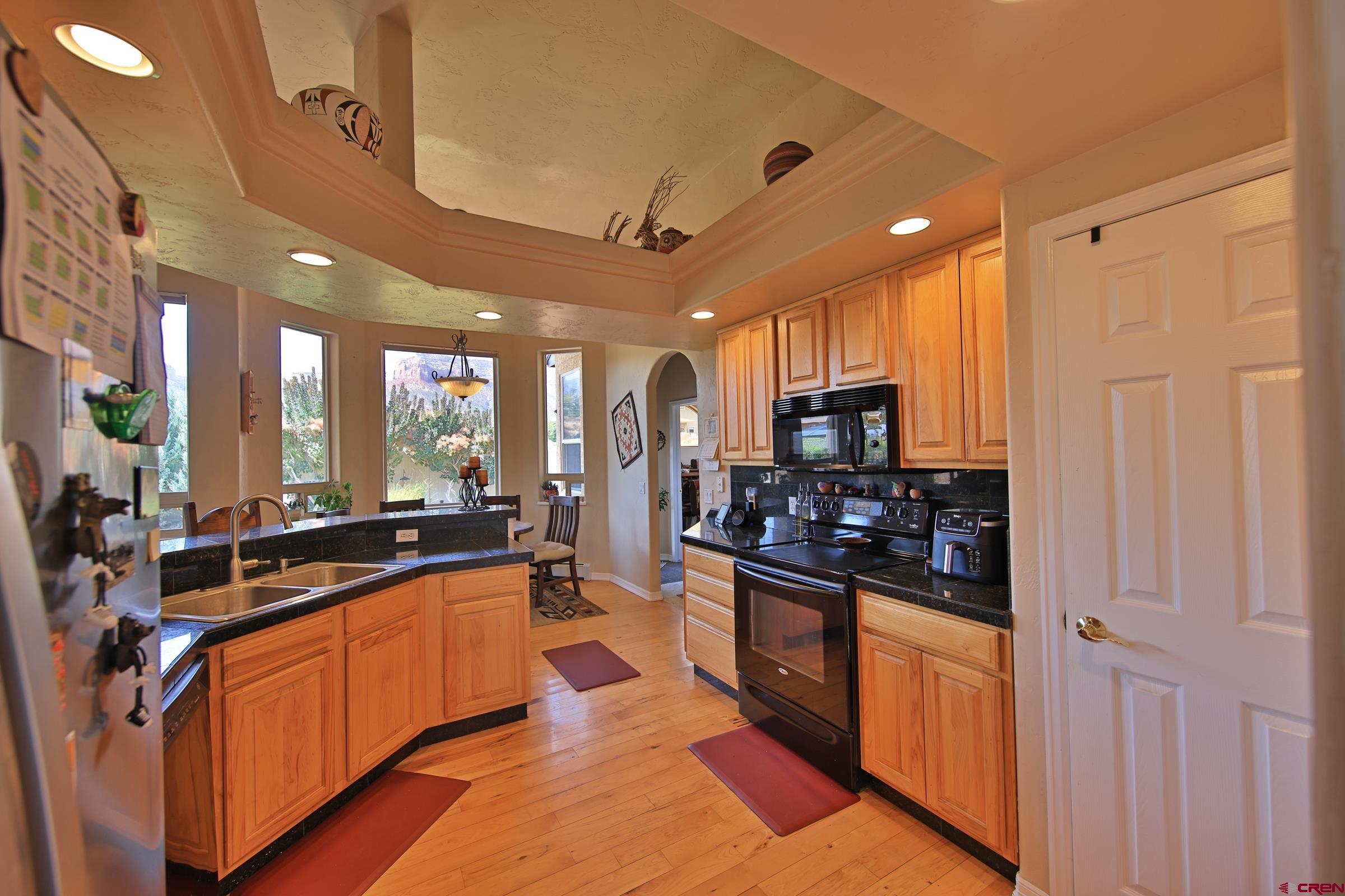 339 Canyon Rim Court Grand Junction, CO 81507 - Photo 13 of 40 a large kitchen with stainless steel appliances lots of counter space and a sink