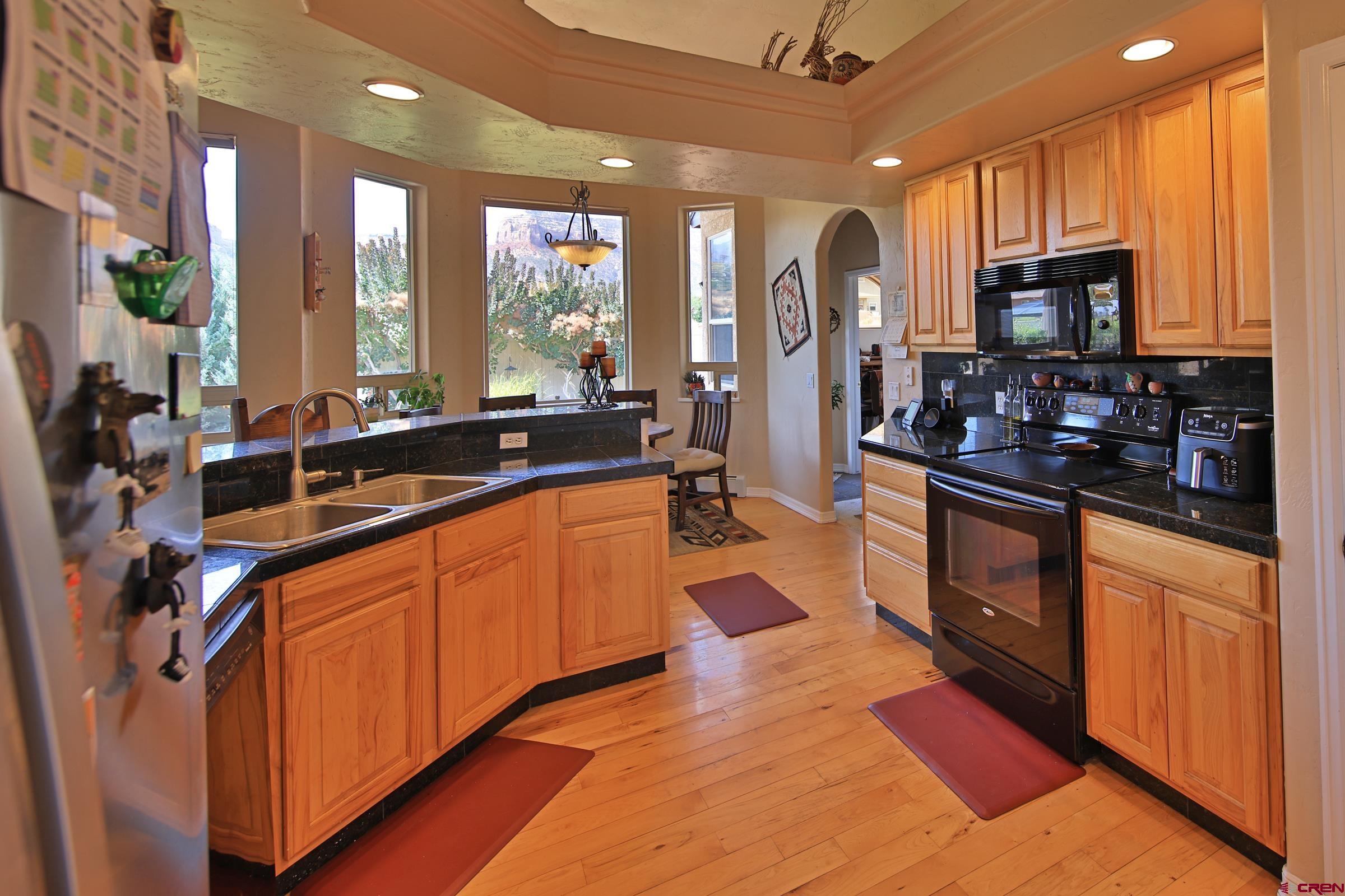 339 Canyon Rim Court Grand Junction, CO 81507 - Photo 14 of 40 a large kitchen with kitchen island granite countertop a large counter top stainless steel appliances and cabinets