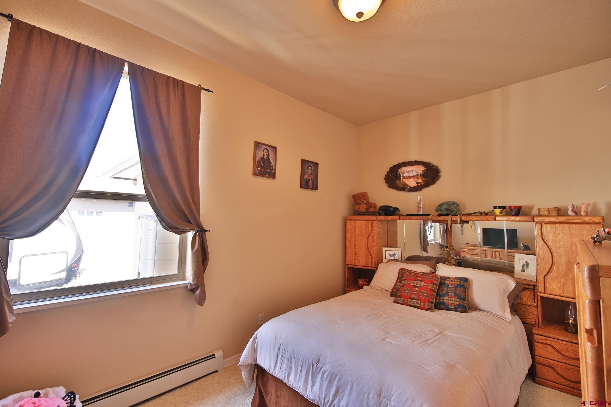 339 Canyon Rim Court Grand Junction, CO 81507 - Photo 19 of 40 a bedroom with a bed and a window