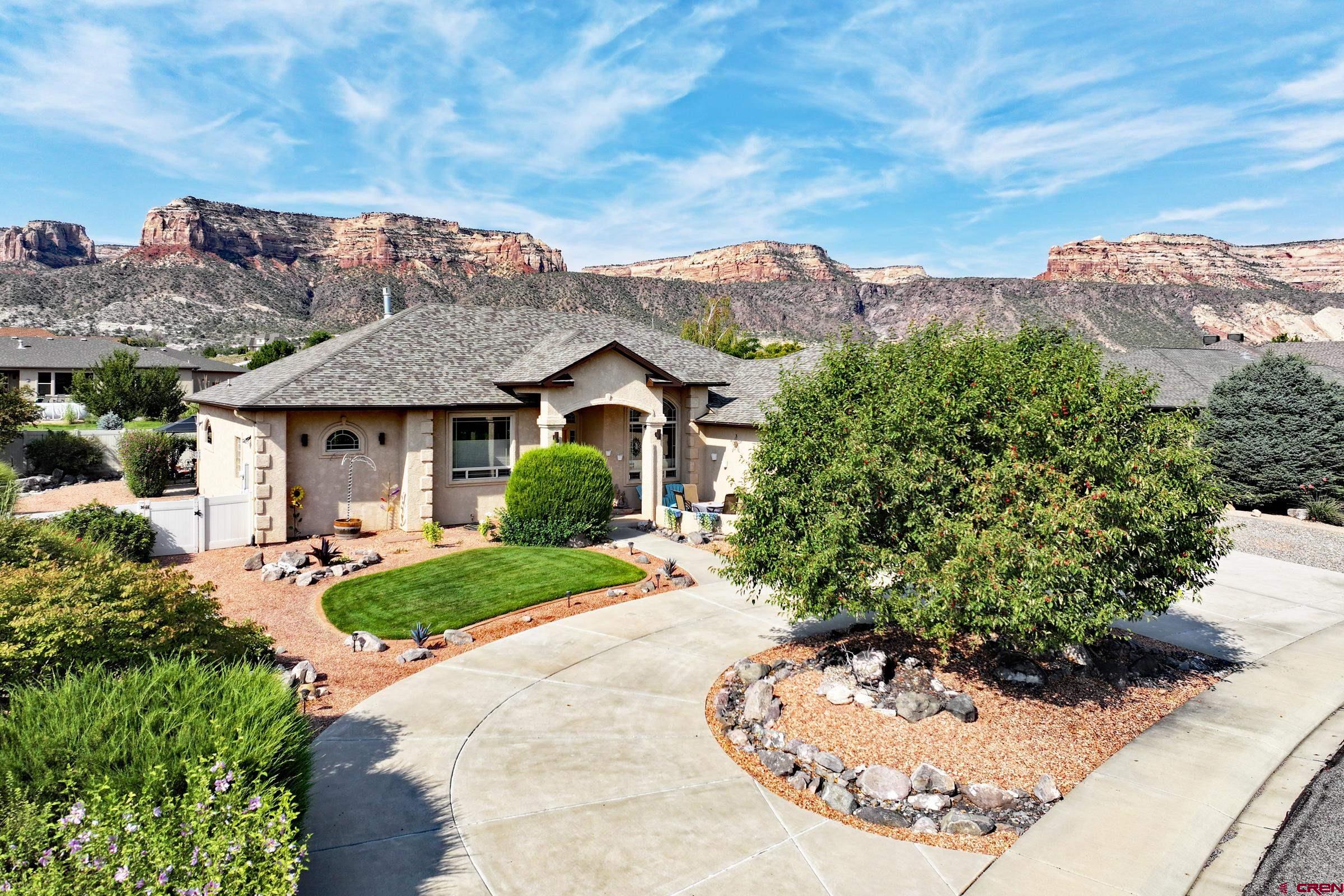 339 Canyon Rim Court Grand Junction, CO 81507 - Photo 2 of 40 a view of a white house with a yard garden and outdoor seating