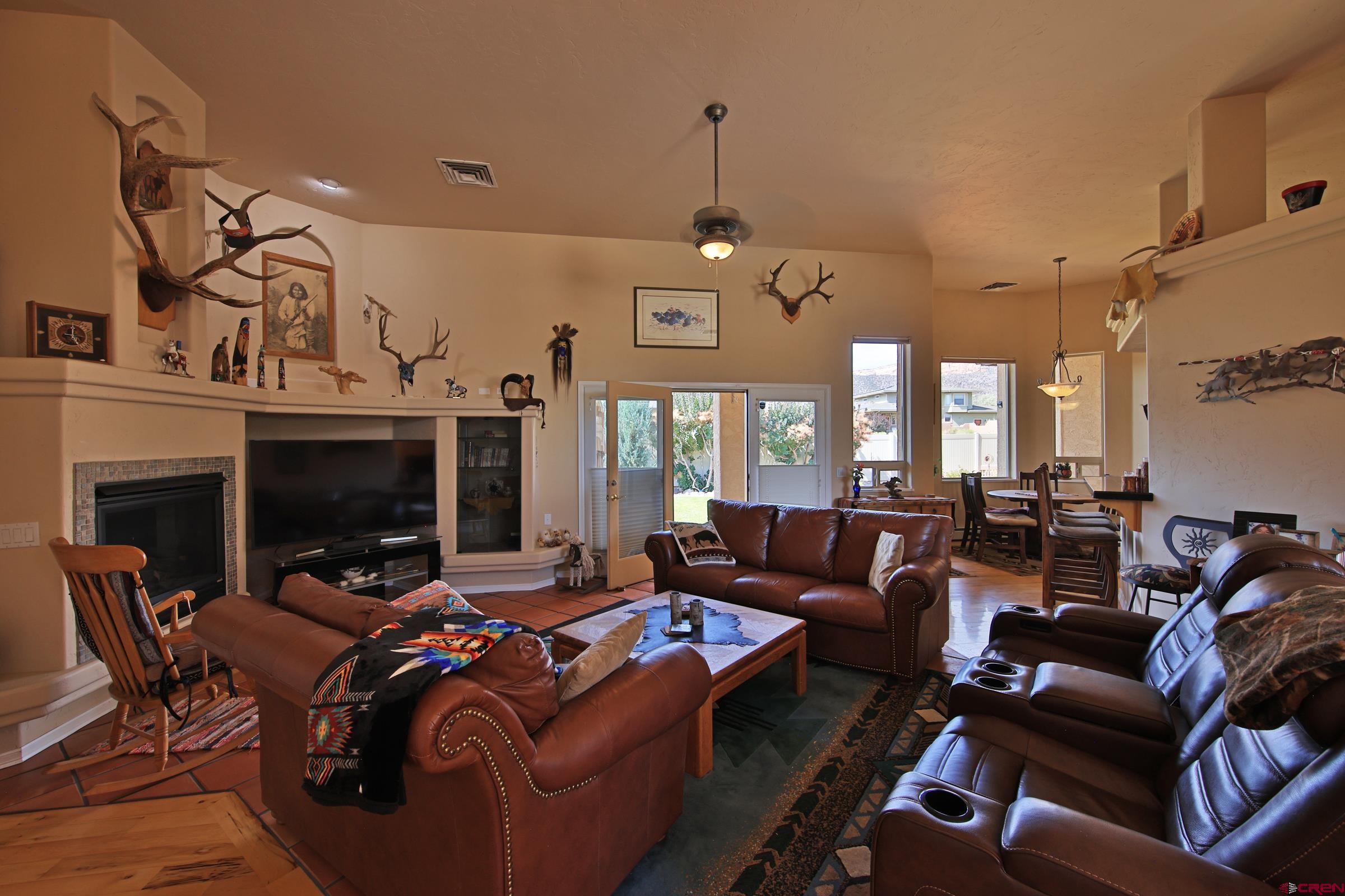 339 Canyon Rim Court Grand Junction, CO 81507 - Photo 9 of 40 a living room with furniture a fireplace and a chandelier