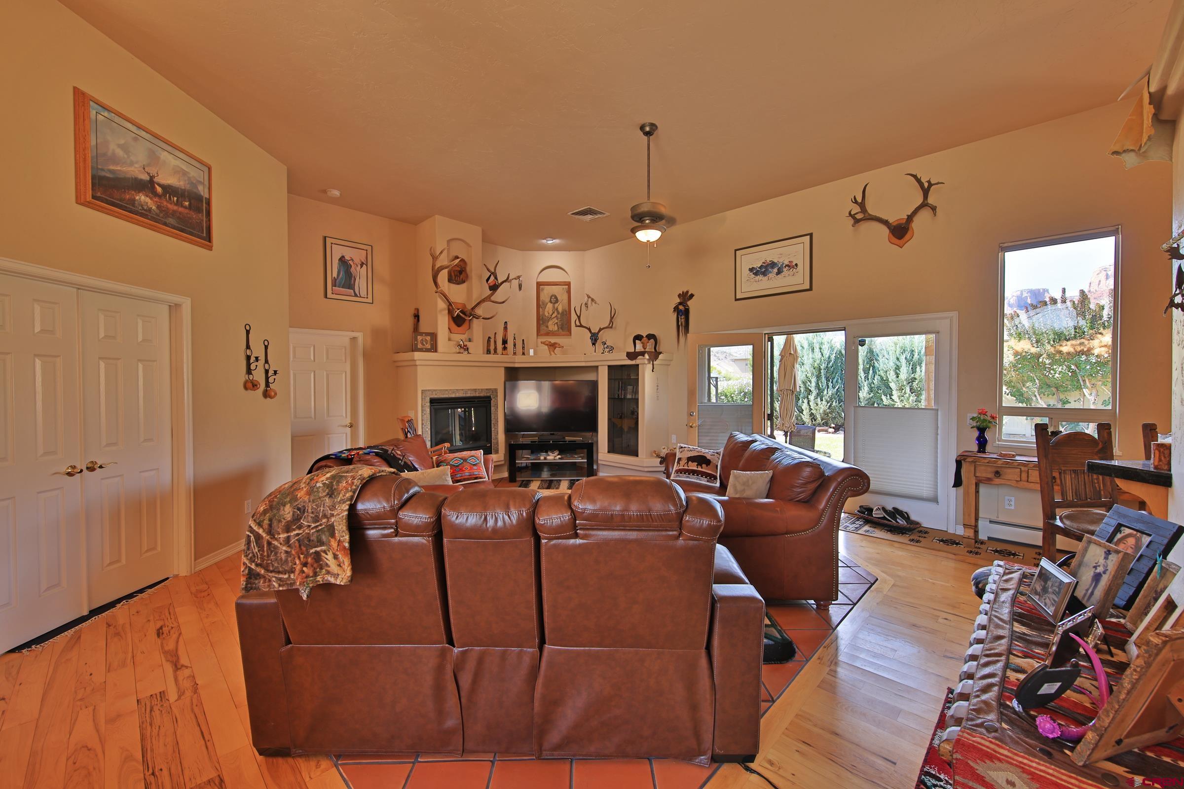 339 Canyon Rim Court Grand Junction, CO 81507 - Photo 10 of 40 a living room with furniture a flat screen tv and a floor to ceiling window