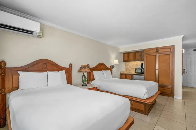 a bedroom with a bed and a lamp on dresser