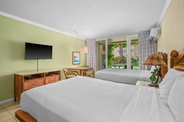 a bedroom with a bed and large windows