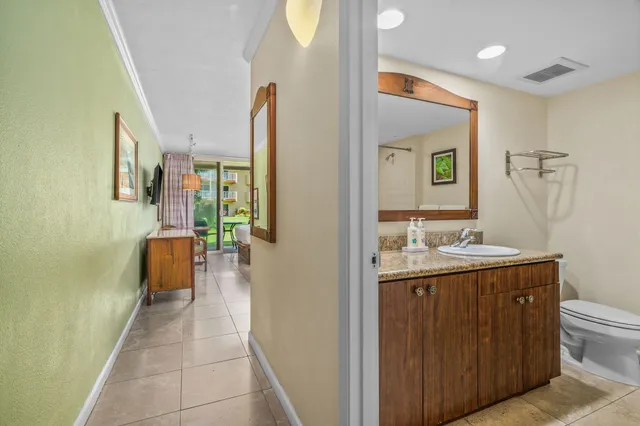 a en suite bathroom with a granite countertop sink and a mirror