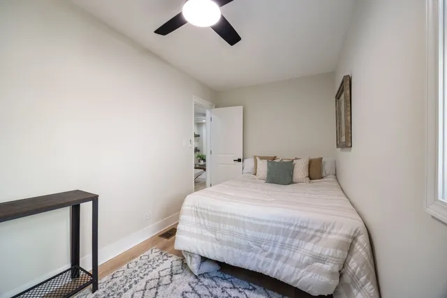 a bedroom with a large bed and wooden floor