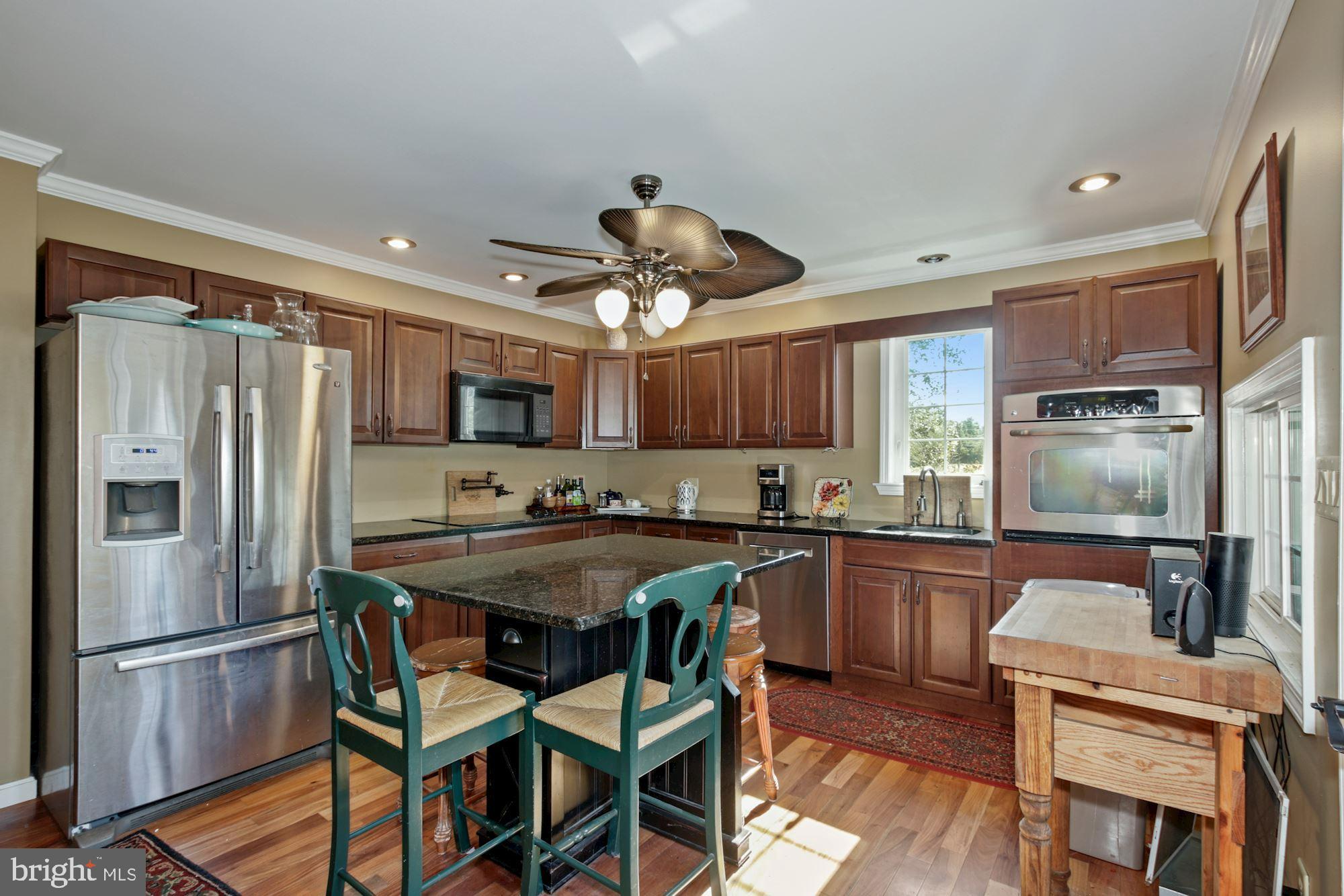 87 Eayrestown Road Medford, NJ 08055 - Photo 11 of 37 a kitchen with stainless steel appliances granite countertop a refrigerator a sink dishwasher a dining table and chairs with wooden floor