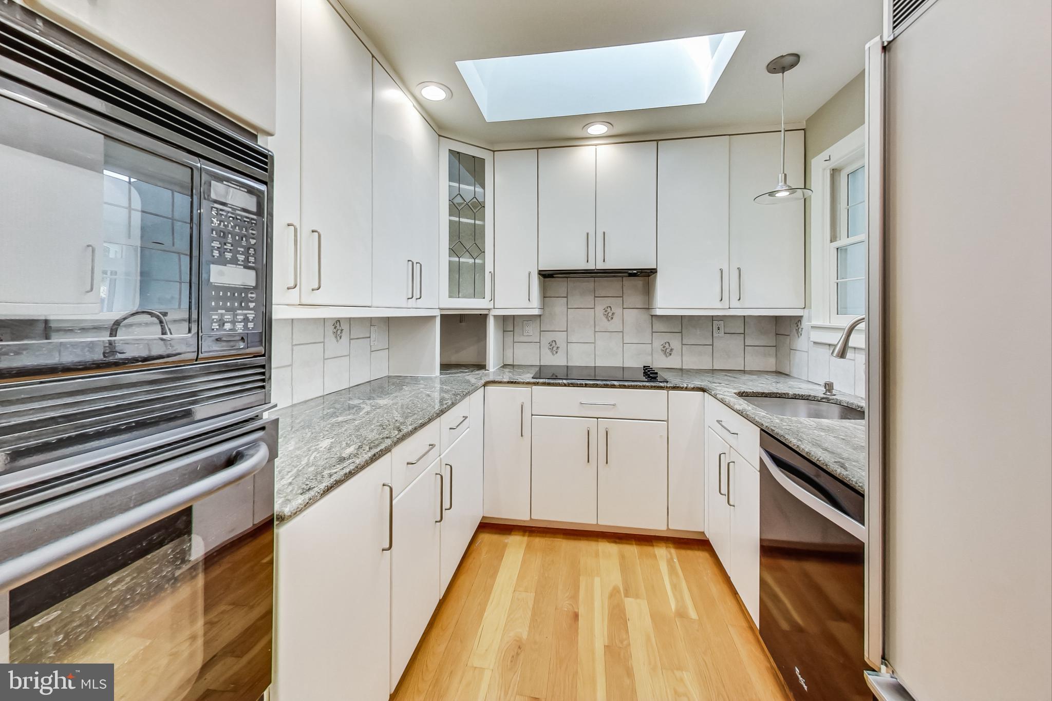 4513 Puller Drive Kensington, MD 20895 - Photo 3 of 46 a kitchen with granite countertop white cabinets and white appliances