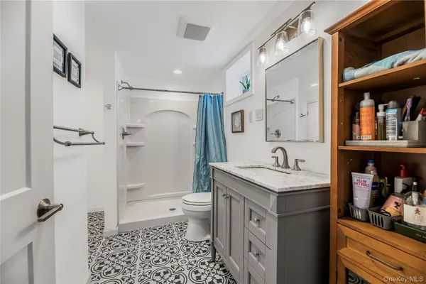 a bathroom with a granite countertop sink toilet and shower
