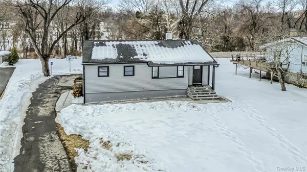 a view of a house with snow on the side of the road
