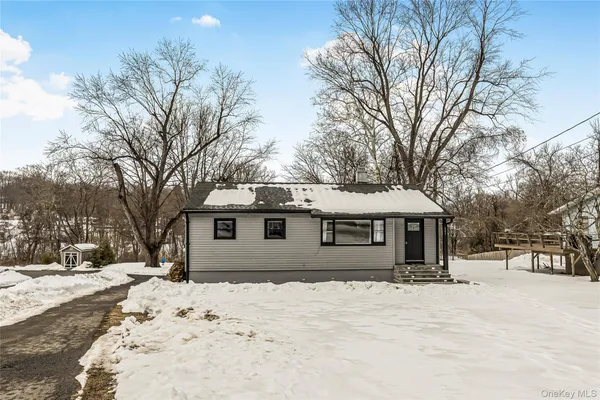 a front view of a house with a yard covered in snow