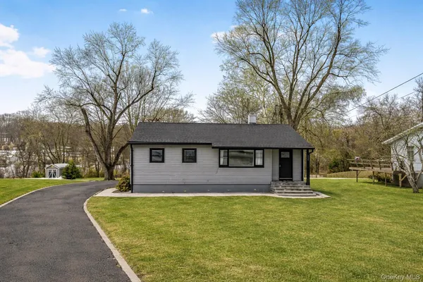 a front view of house with yard and trees