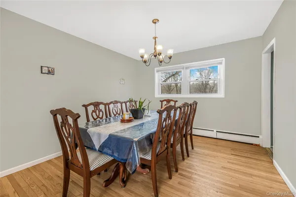 a view of a dining room with furniture a chandelier and wooden floor