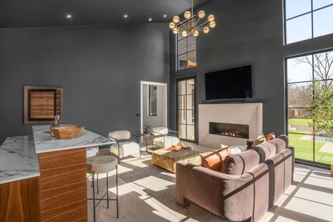 a living room with furniture and a floor to ceiling window