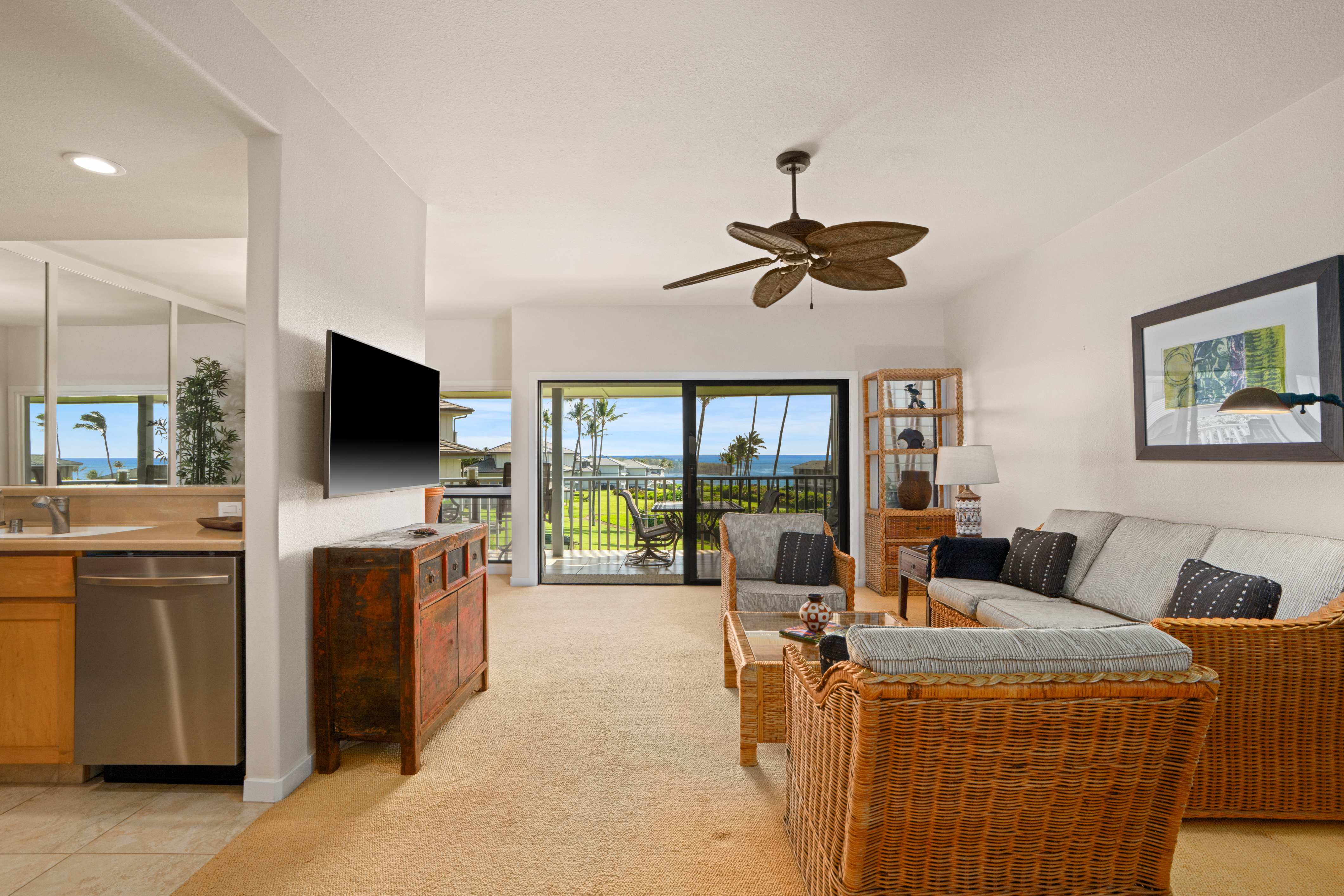 1565 Pe'e Road, Unit 125 Koloa, HI 96756 - Photo 17 of 20 a living room with furniture a flat screen tv and a large window