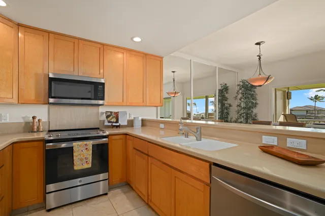 a kitchen with stainless steel appliances granite countertop a sink a stove and a microwave