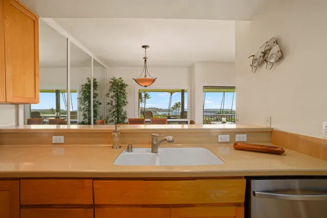 a view of a kitchen with kitchen island a counter space and a sink