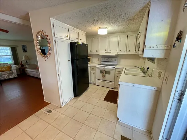 a kitchen with a refrigerator sink stove and cabinets