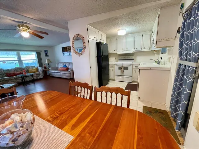 a kitchen with stainless steel appliances granite countertop a refrigerator a stove a sink dishwasher and white cabinets with wooden floor