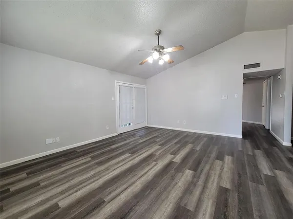 a view of empty room with wooden floor