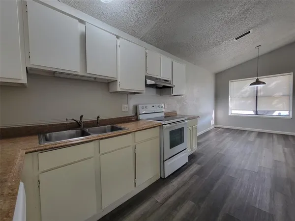 a kitchen with sink a microwave and cabinets