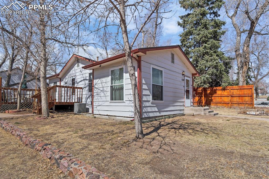 1128 Alexander Road Colorado Springs, CO 80909 - Photo 1 of 26 a backyard of a house with oven and trees