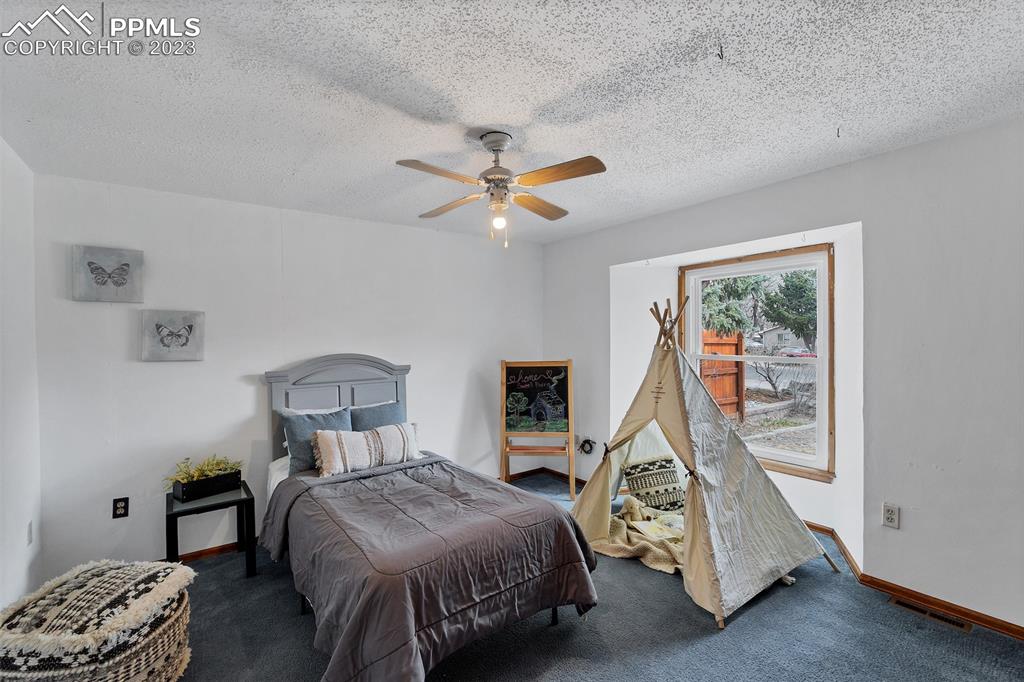 1128 Alexander Road Colorado Springs, CO 80909 - Photo 11 of 26 a bedroom with bed and a window