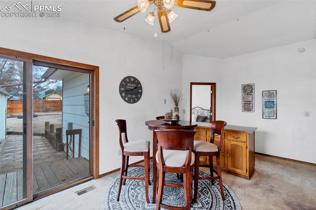 1128 Alexander Road Colorado Springs, CO 80909 - Photo 14 of 26 a view of a dining room and livingroom with furniture window and wooden floor