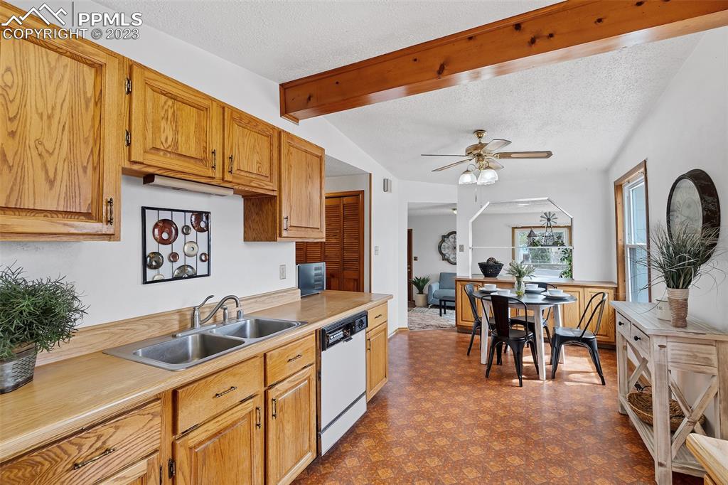 1128 Alexander Road Colorado Springs, CO 80909 - Photo 6 of 26 a view of a kitchen area with furniture and chandelier