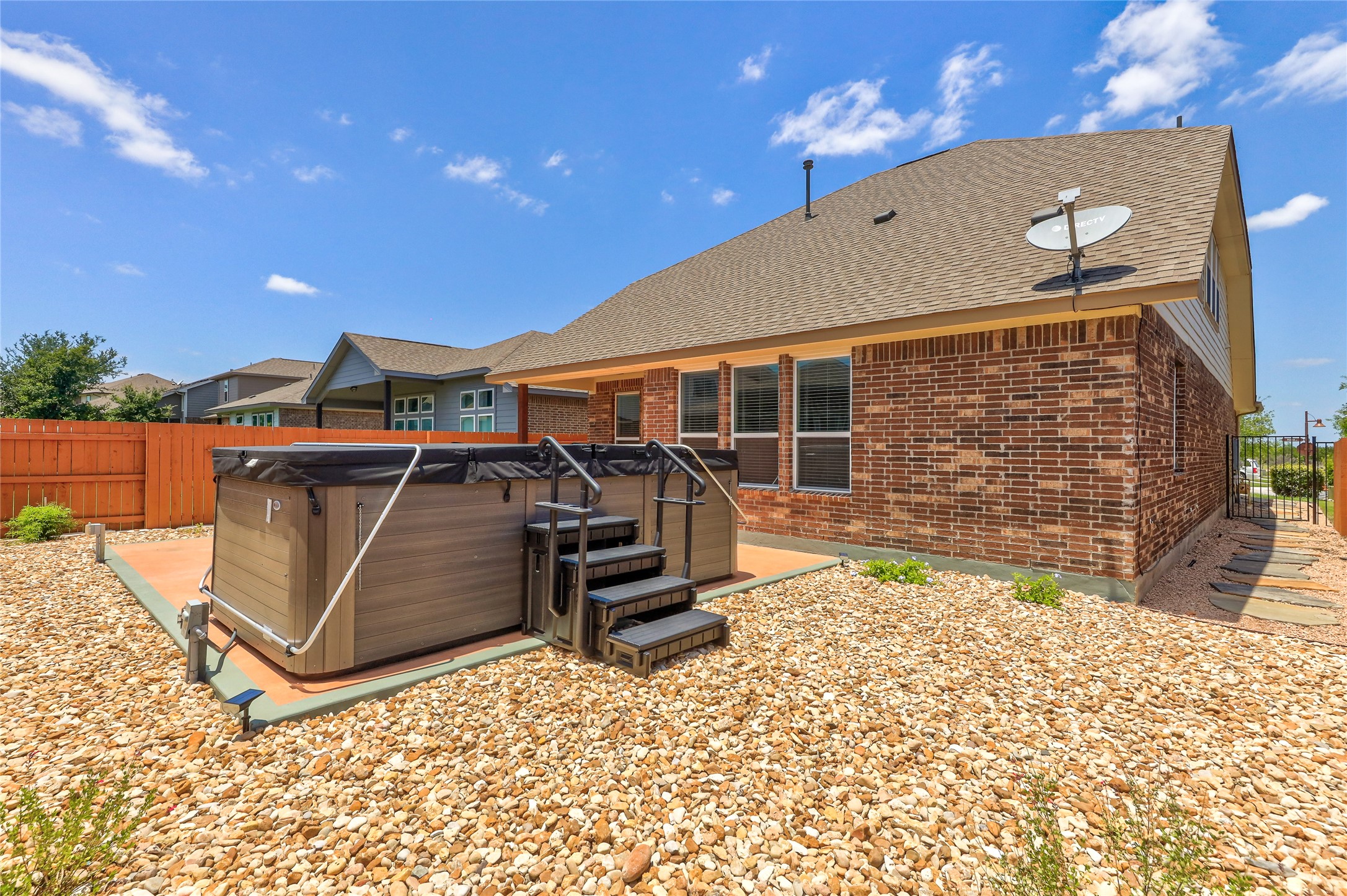 205 Penna Lane Georgetown, TX 78628 - Photo 31 of 32 A spacious backyard features a hot tub, ideal for relaxation and entertaining, with a secure wooden fence.