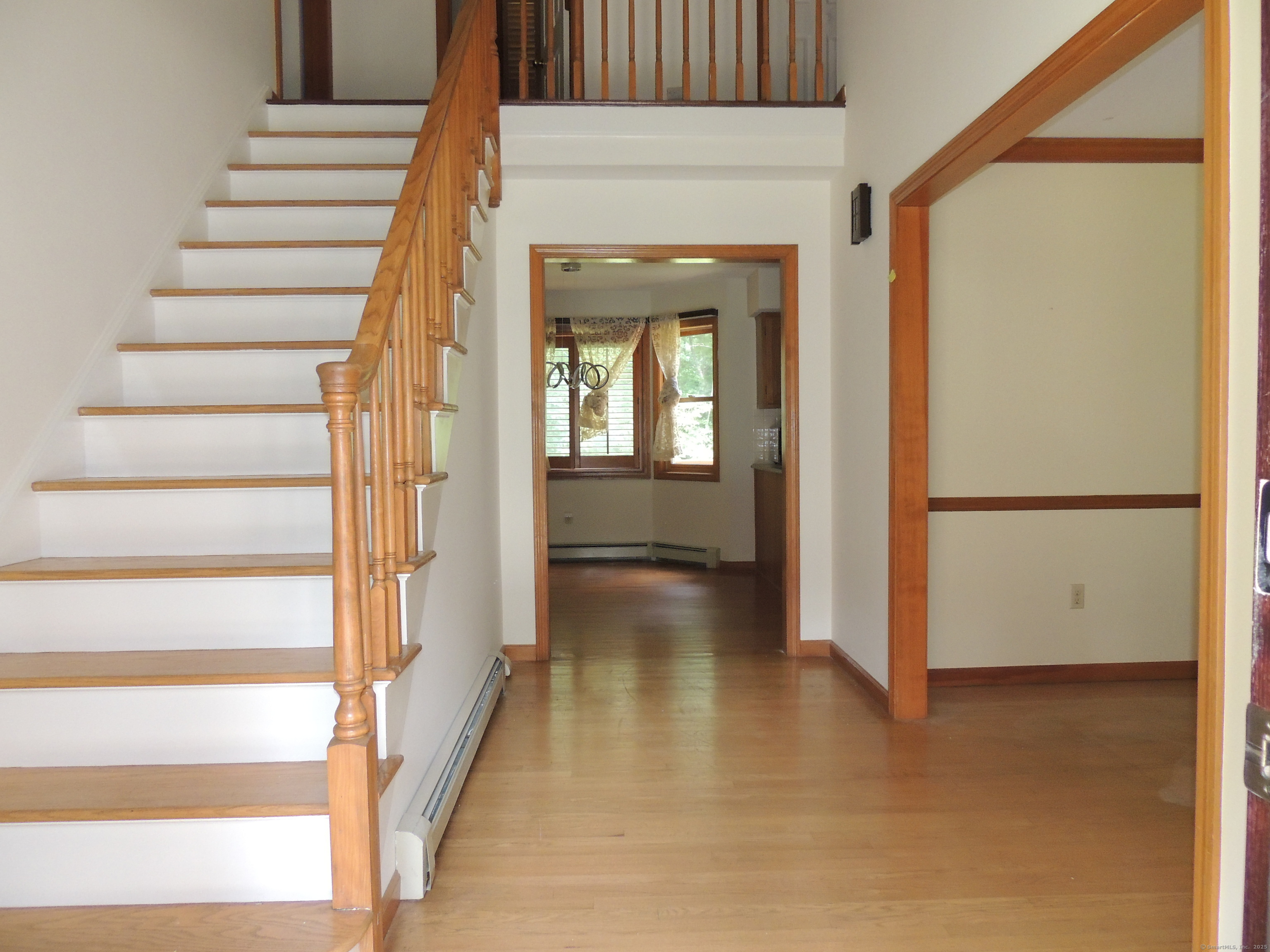 12 Cardinal Lane Monroe, CT 06468 - Photo 3 of 38 a view of a hallway with wooden floor and entryway
