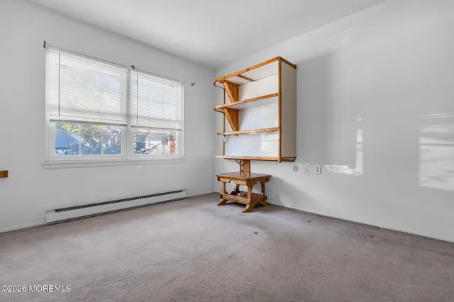 an empty room with windows and mirror