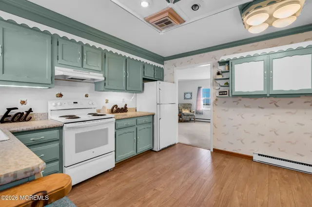 a kitchen with granite countertop a stove a sink and a refrigerator