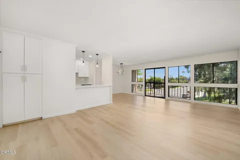 a view of an empty room with wooden floor and a floor to ceiling window