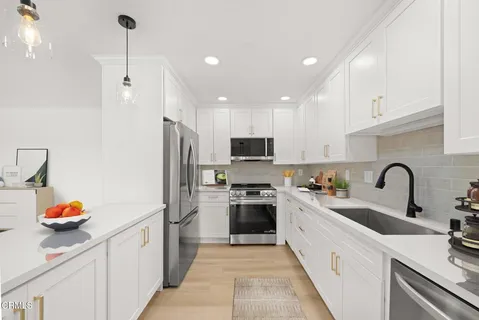 a kitchen with stainless steel appliances granite countertop a sink refrigerator and cabinets