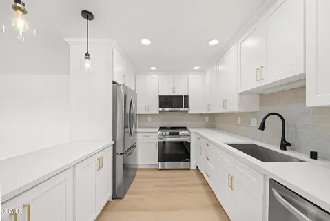 a kitchen with stainless steel appliances a sink stove and refrigerator