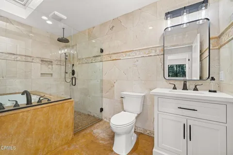 a bathroom with a sink toilet a mirror and shower