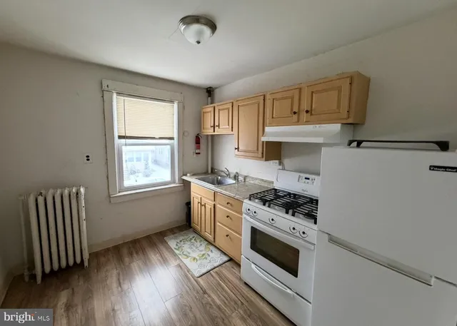a kitchen with granite countertop a stove and a wooden floors