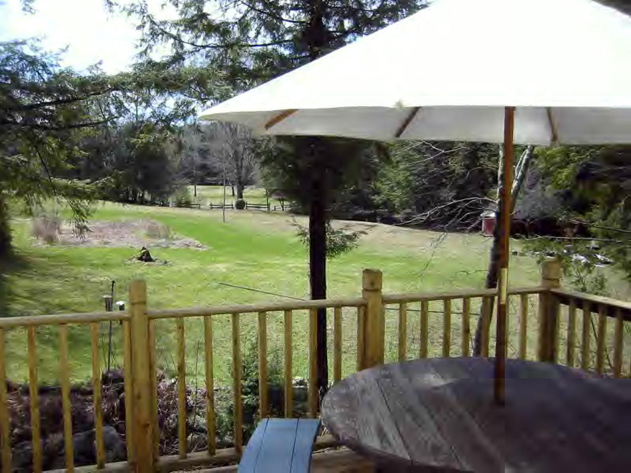 669 Sandmill Road Cheshire, MA 01225 - Photo 5 of 6 a view of a deck with a table and chairs under an umbrella