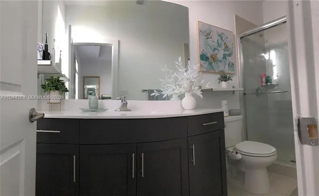 a bathroom with a sink vanity mirror and toilet