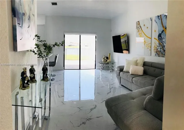 a living room with furniture a flat screen tv and a large window