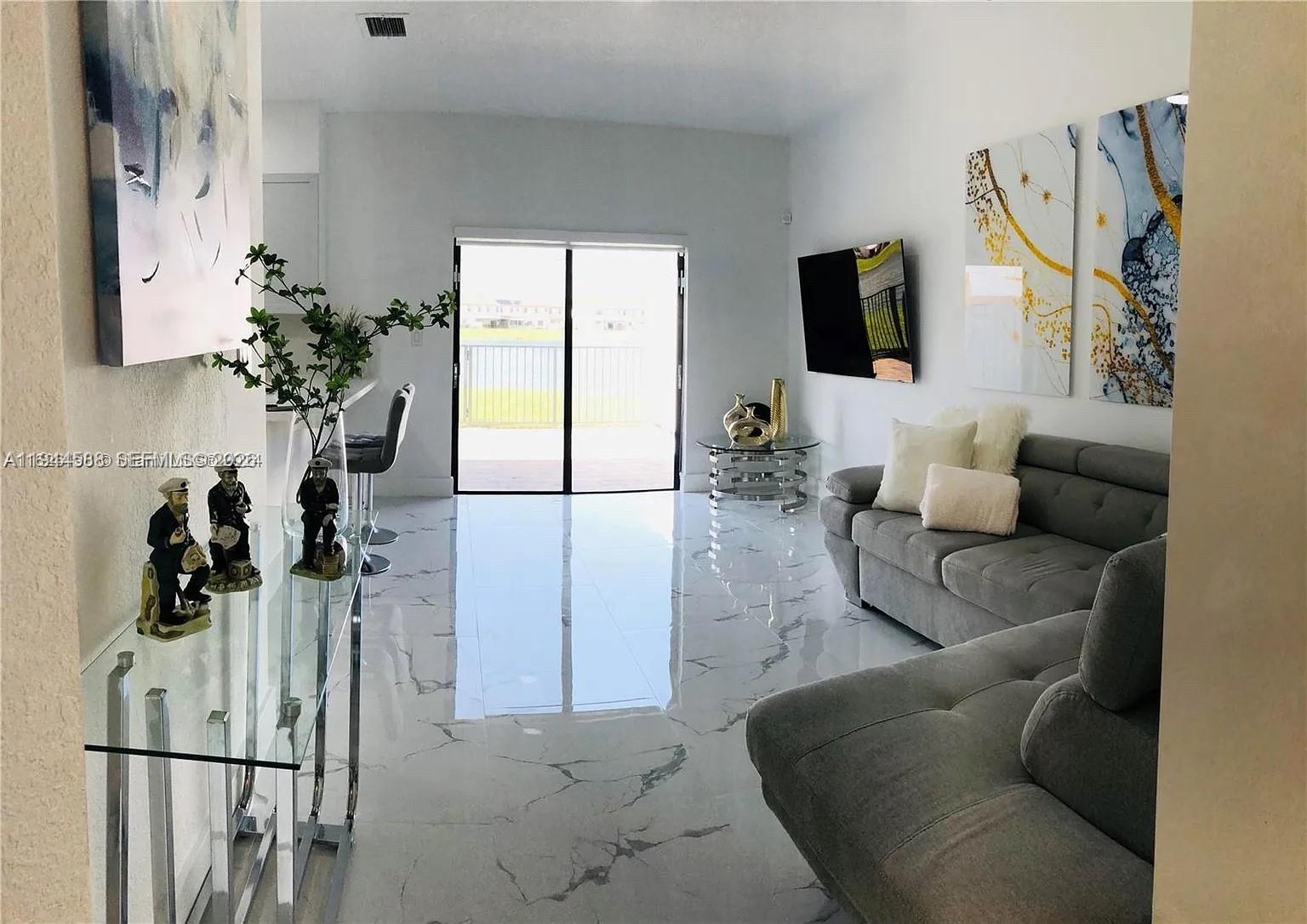 10162 Southwest 228th Terrace Miami, FL 33190 - Photo 6 of 20 a living room with furniture a flat screen tv and a large window