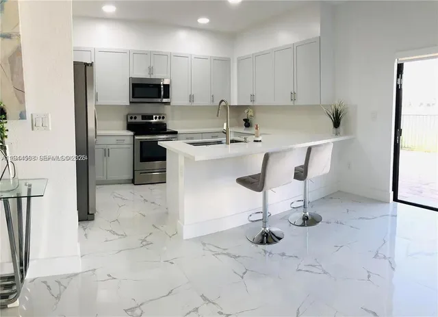 a kitchen with stainless steel appliances a stove a sink and a refrigerator