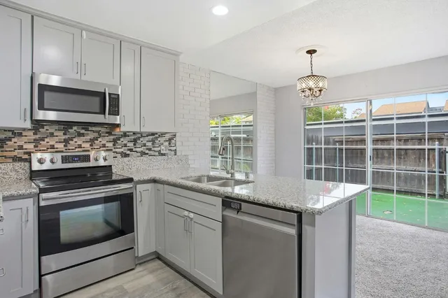 a kitchen with stainless steel appliances granite countertop a sink stove and microwave