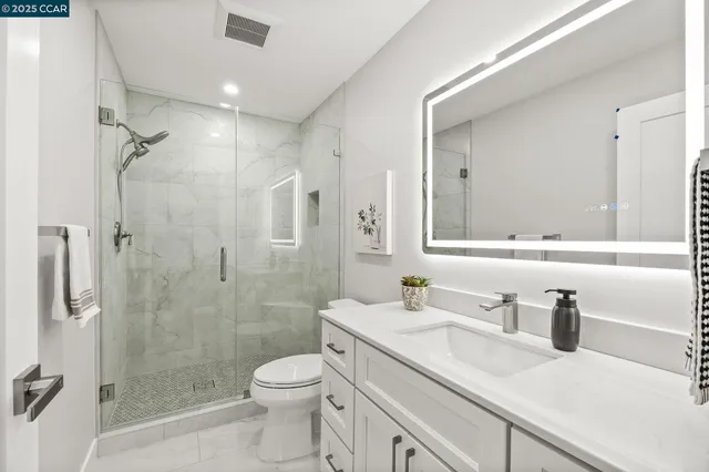 a bathroom with a granite countertop sink a toilet and shower